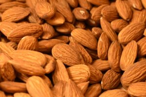 A detailed close-up of harvested almonds, showcasing texture and abundance in a food setting.