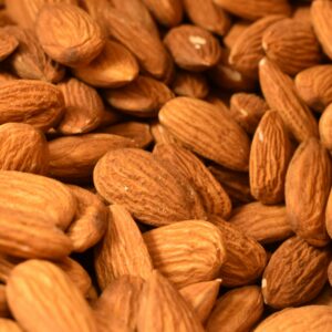 A detailed close-up of harvested almonds, showcasing texture and abundance in a food setting.