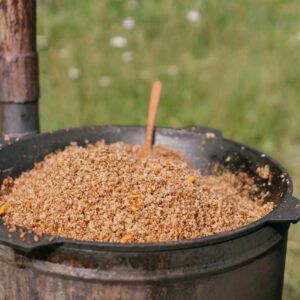 A rustic pot with cooked buckwheat groats on a sunny day outdoors, perfect for food themes.